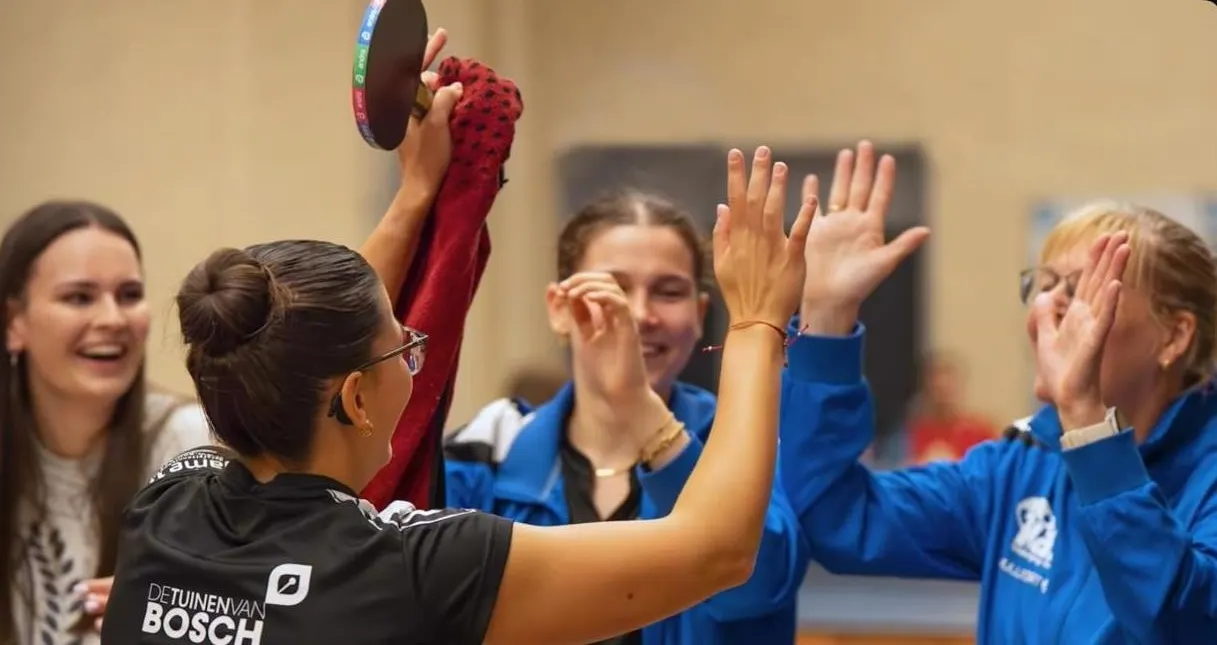 Een tafeltennisster viert een punt met haar team